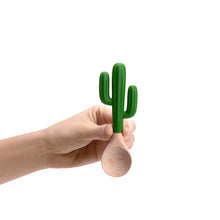 Load image into Gallery viewer, Hand holding a wooden spoon with a green cactus-shaped handle on a white background
